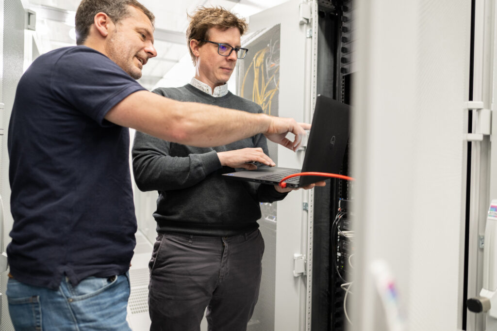 Zwei IT-Kollegen arbeiten am Netzwerkschrank